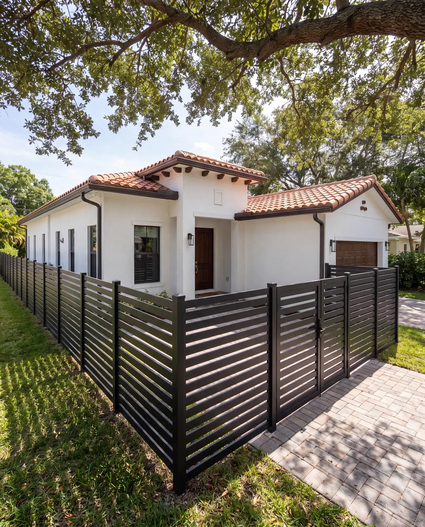 Black horizontal aluminum gate and fence in front of a home