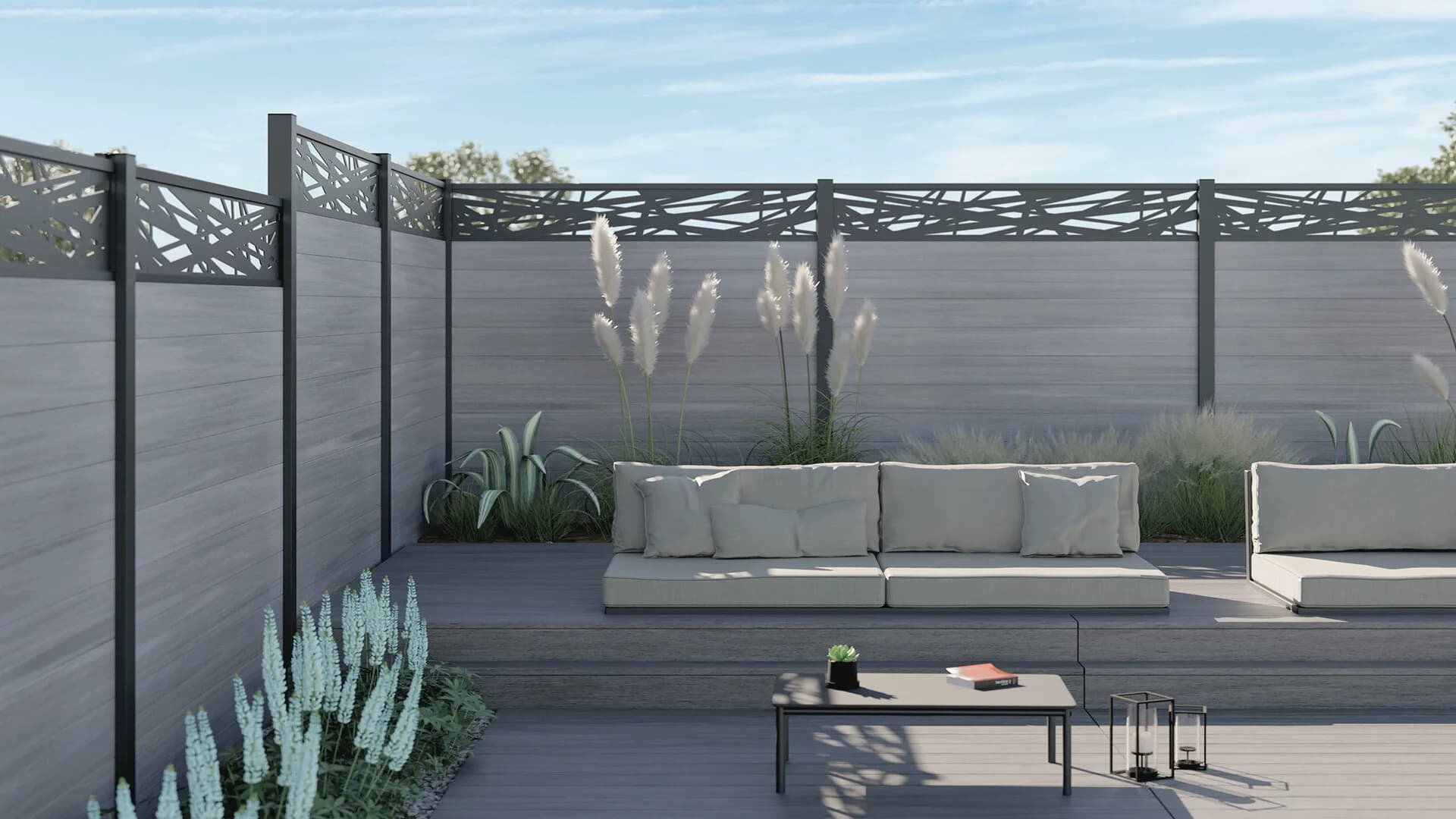 Light grey WPC fence with a decorative laser-cut top panel around a patio lounge