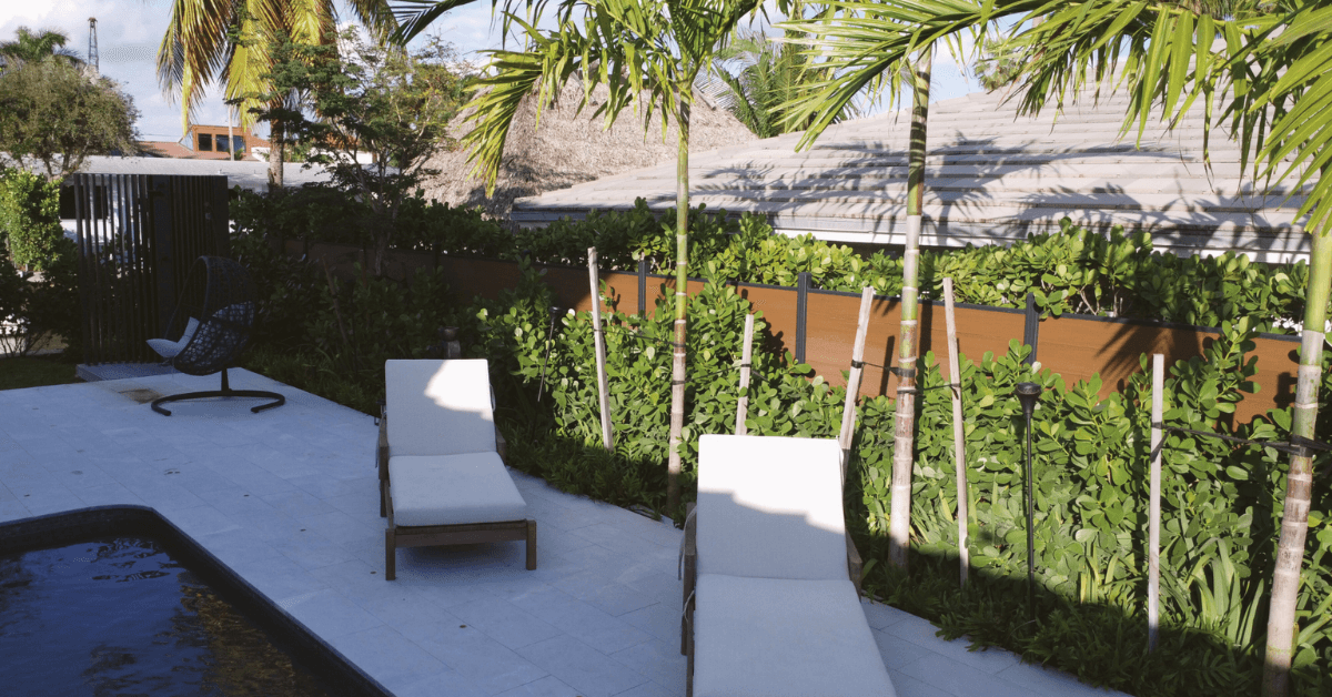 WPC fence tropical garden with lounge chairs