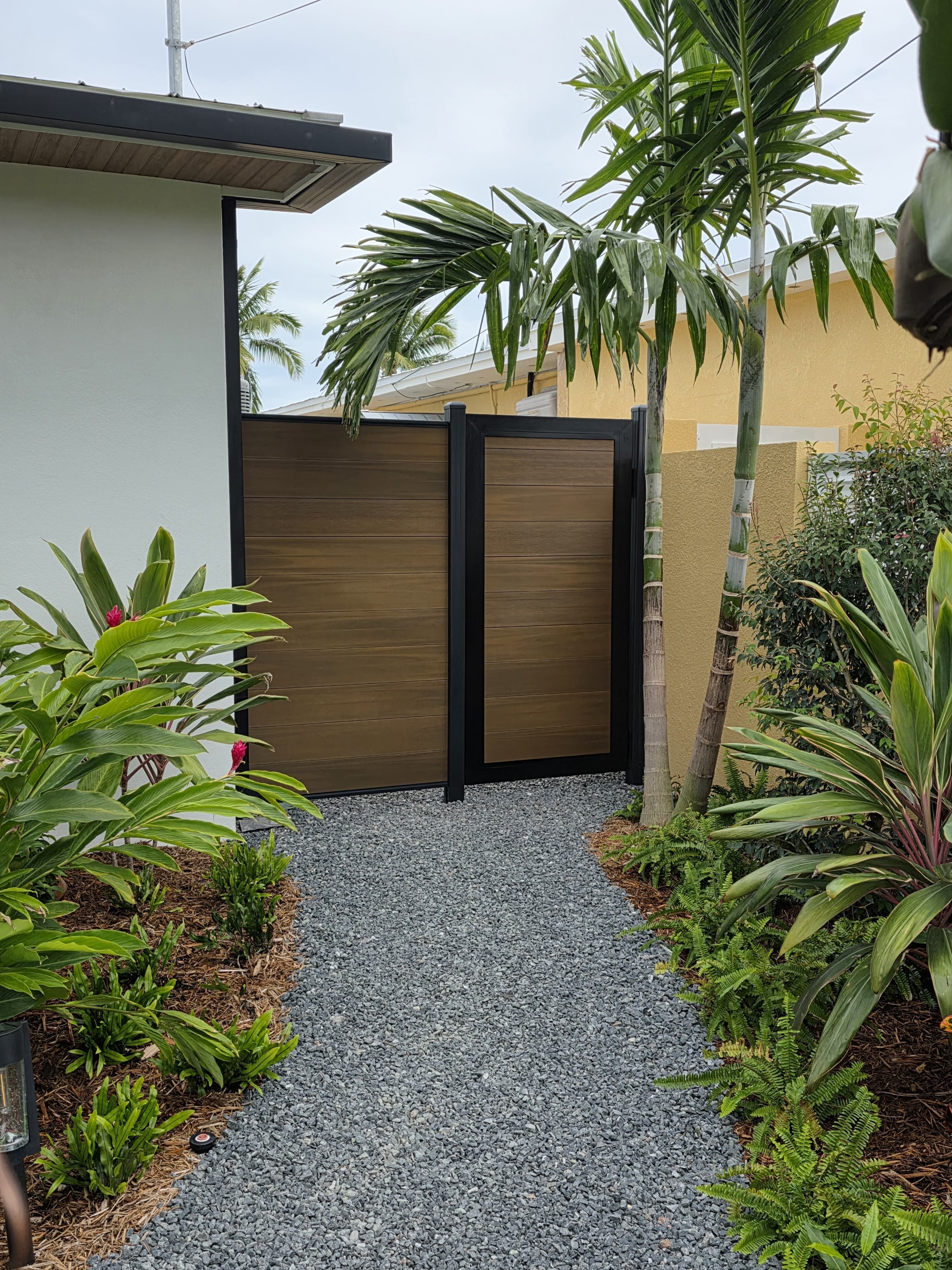 Teak WPC gate with black aluminum frame tropical Miami garden