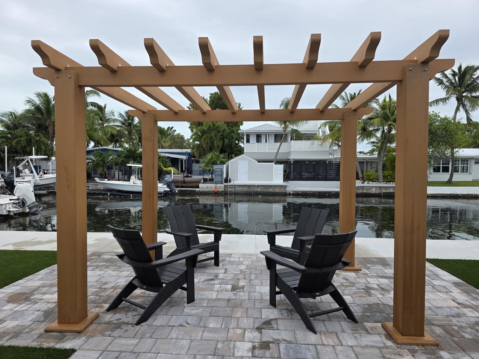 Wood-look WPC pergola over a waterfront paver patio